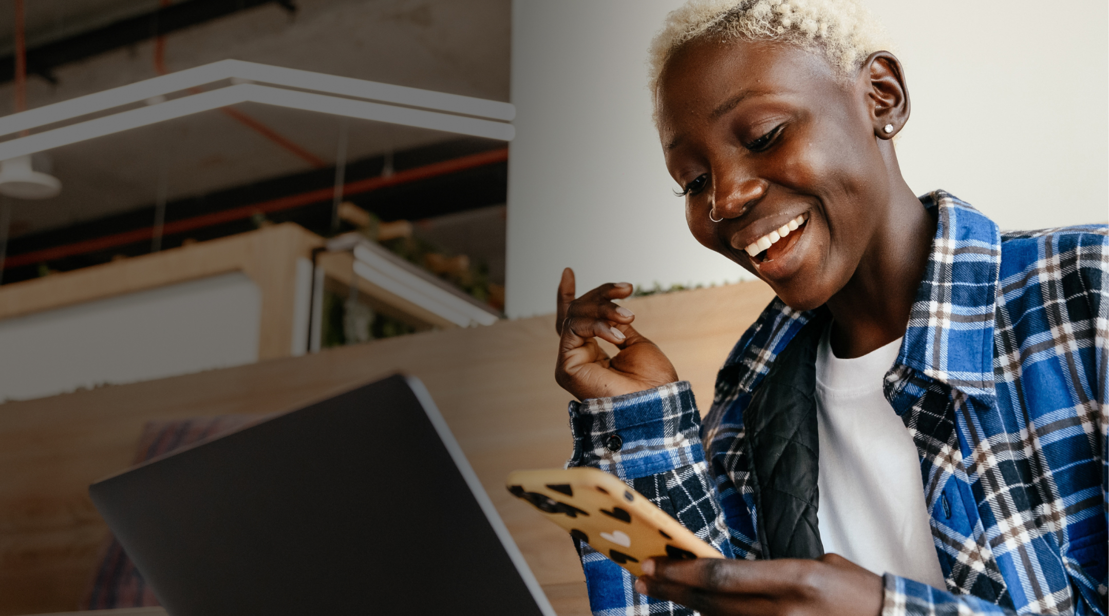 Foto de una mujer mirando su teléfono y sonriendo.